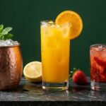 Três drinks com vodka: caneca de cobre, suco de laranja e caipiroska de morango
